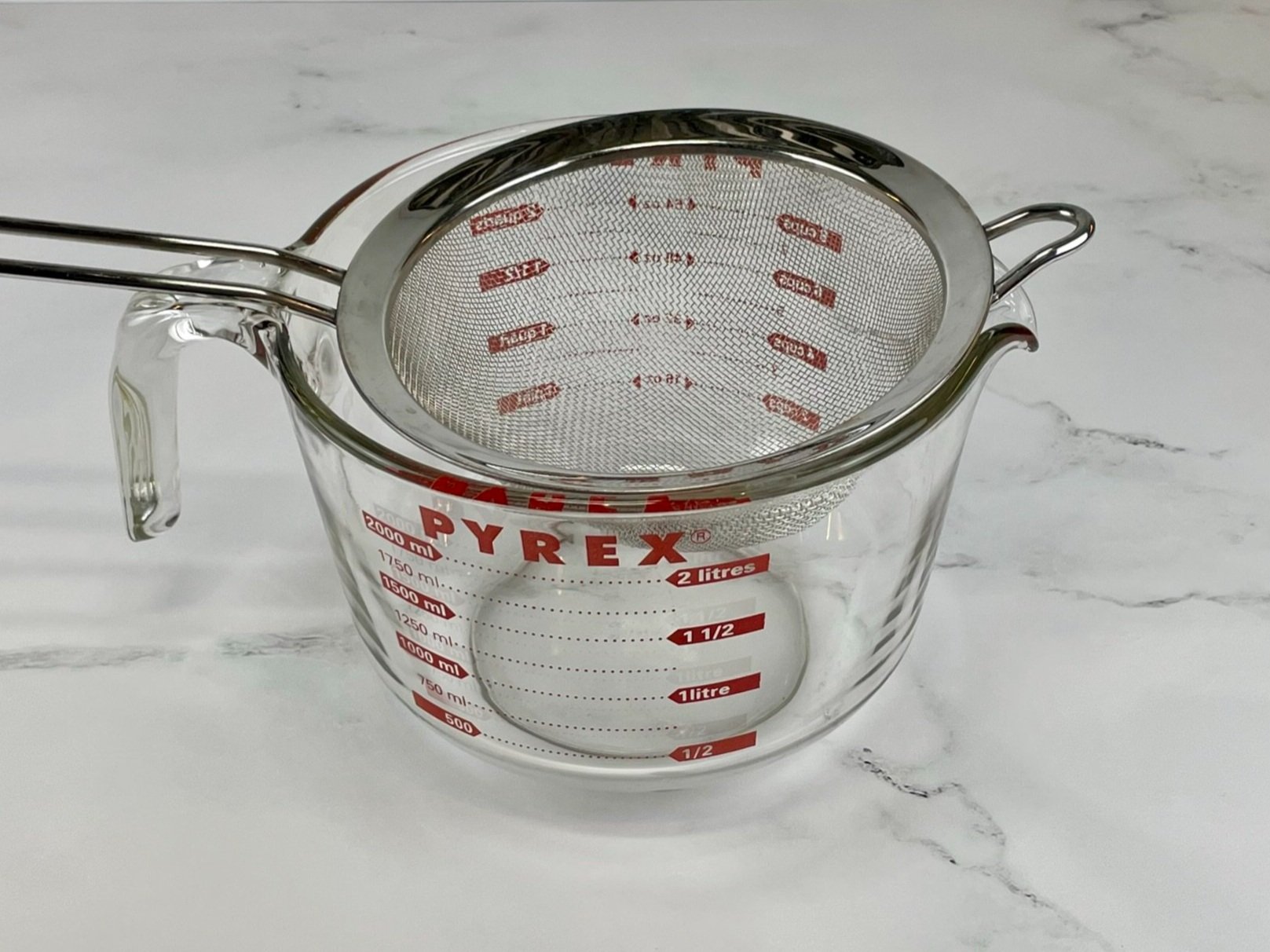 Strainer on measuring cup.