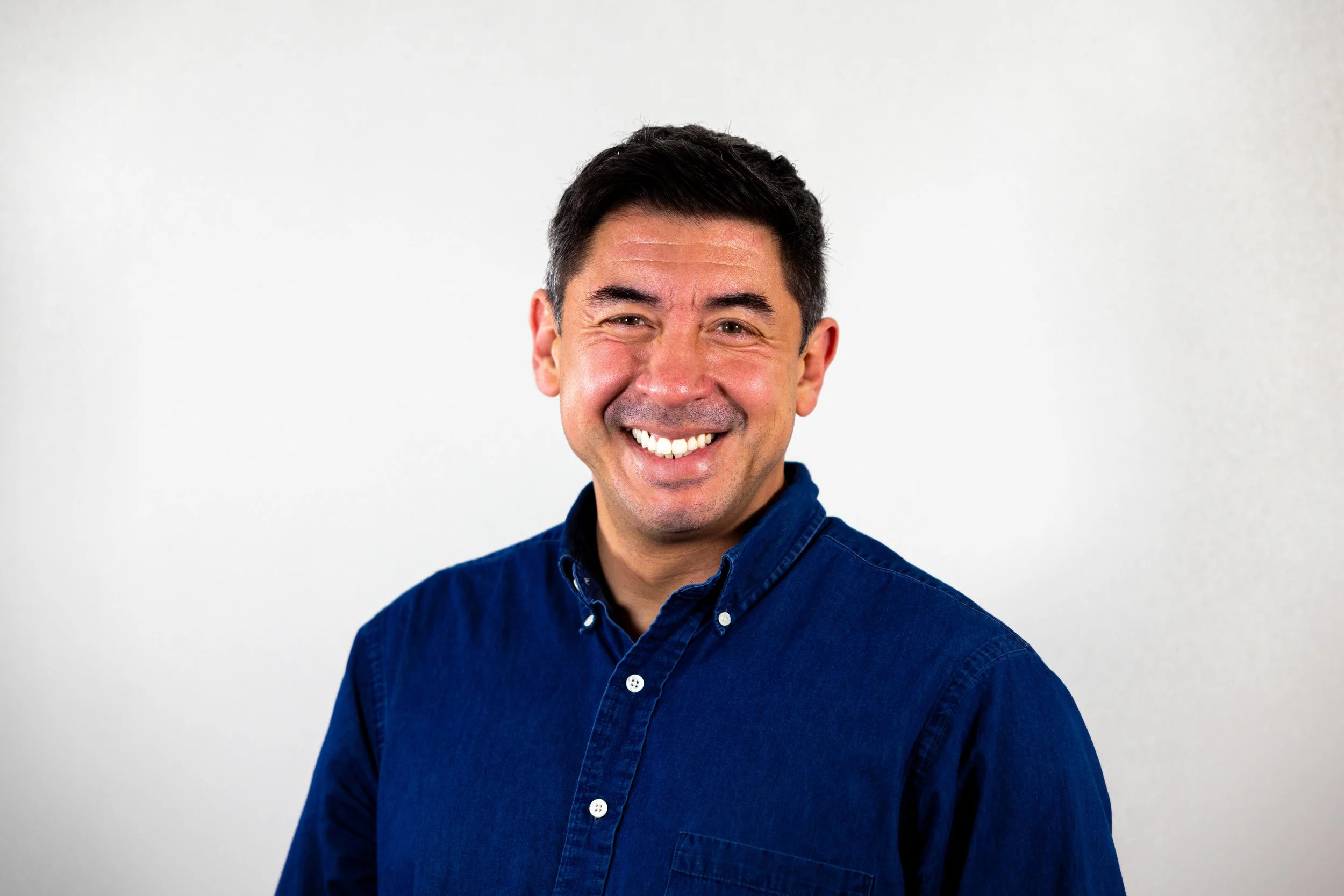 Picture of Nick wearing a blue shirt in front of a white background