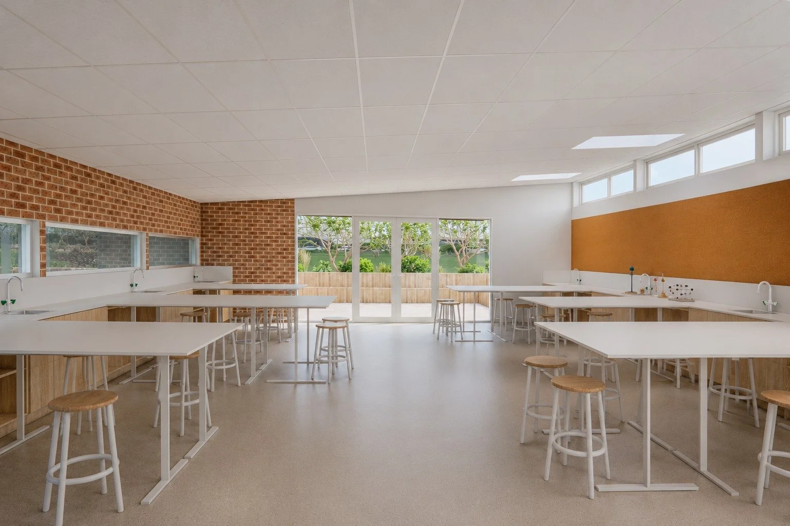 Primary school STEAM learning space with flexible worktables, brick walls and high-level natural light.