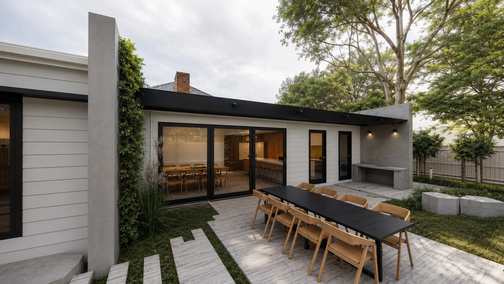 Modern single-story beach house with a flat roof, wooden siding, and large windows, surrounded by coastal landscaping.