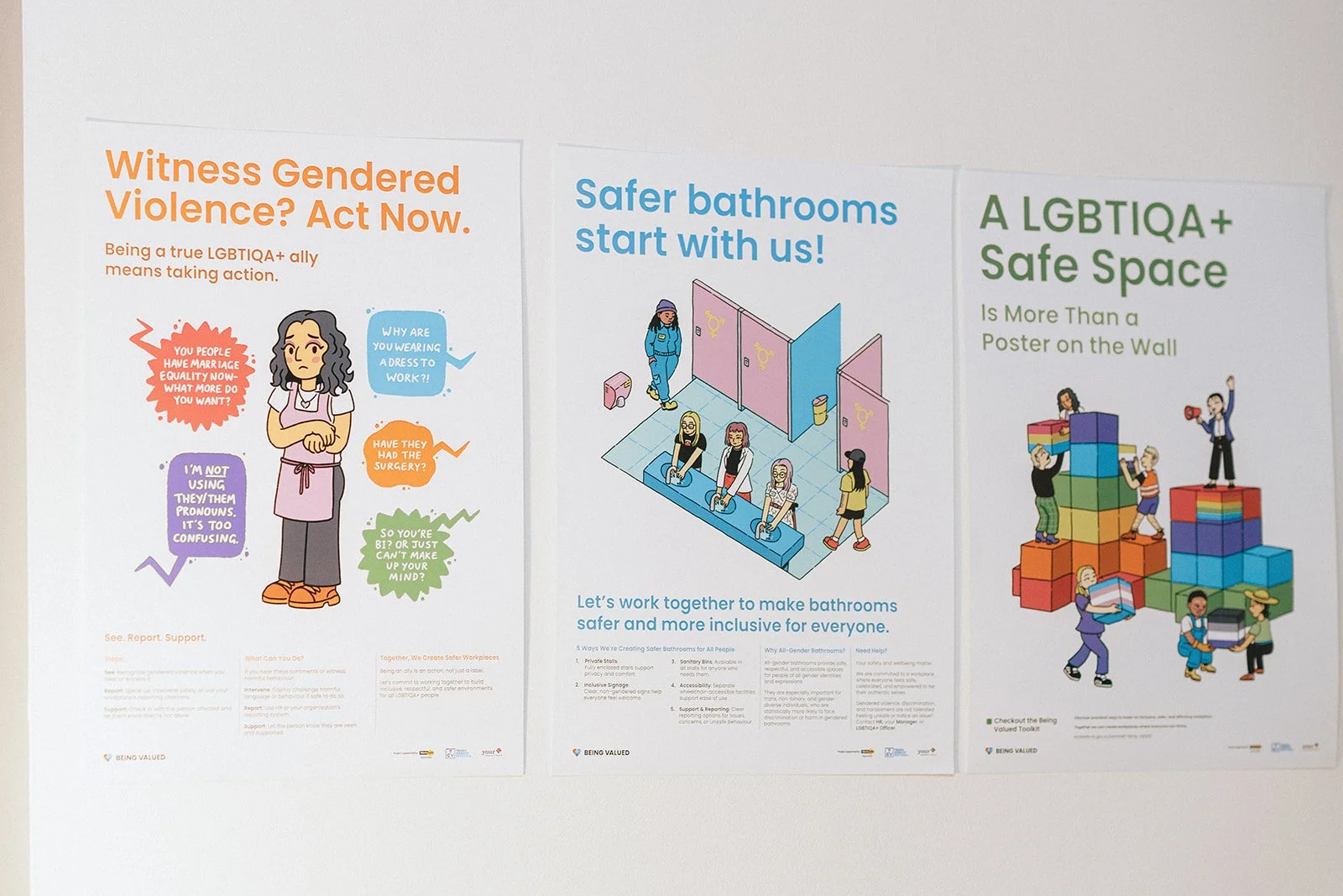 Three posters promoting LGBTQ+ advocacy and safety, including messages about gendered violence, safe bathrooms, and a safe space for LGBTQ+ individuals, featuring illustrations of people and symbols.