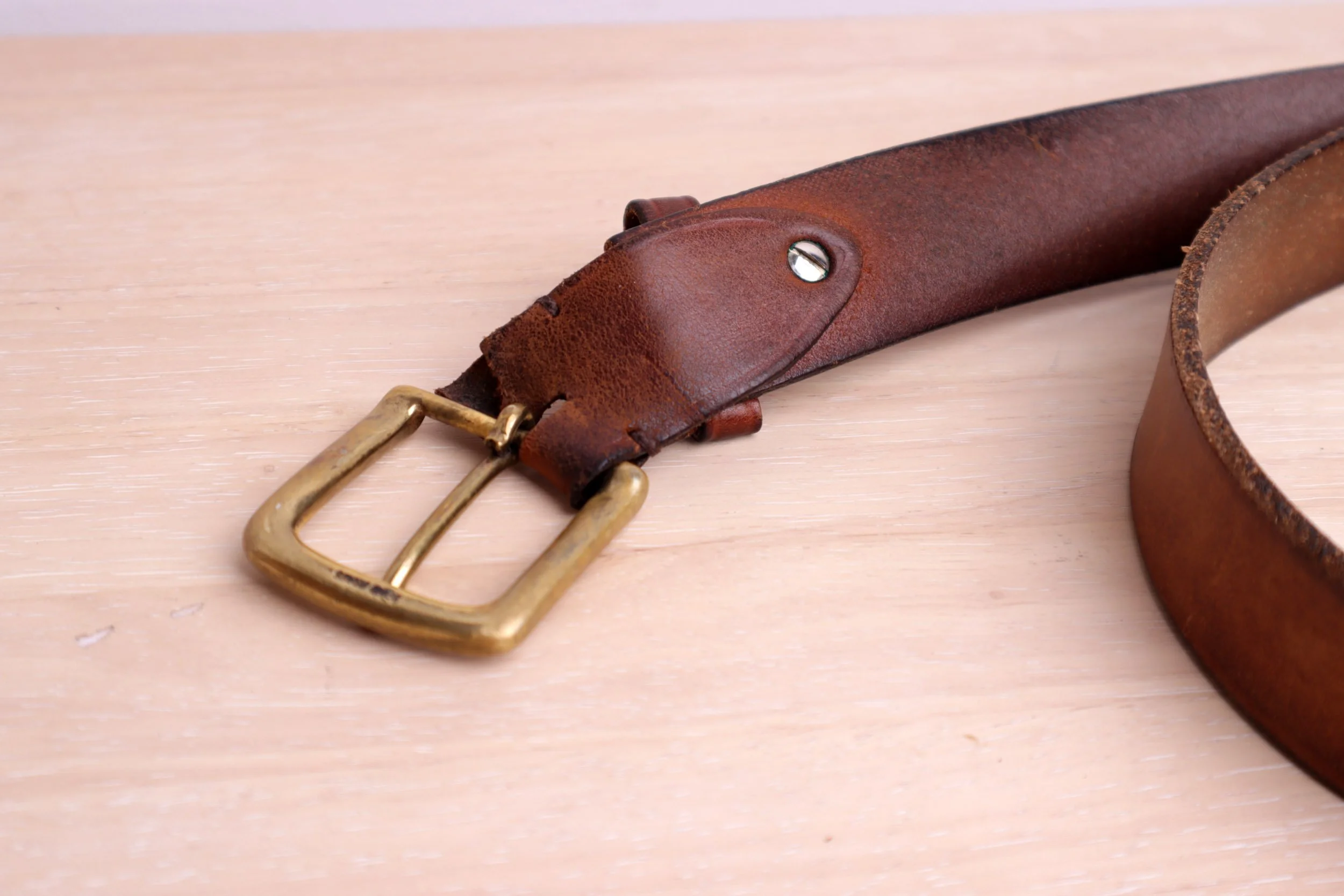 Before Image - broken leather around the buckle on the brown belt