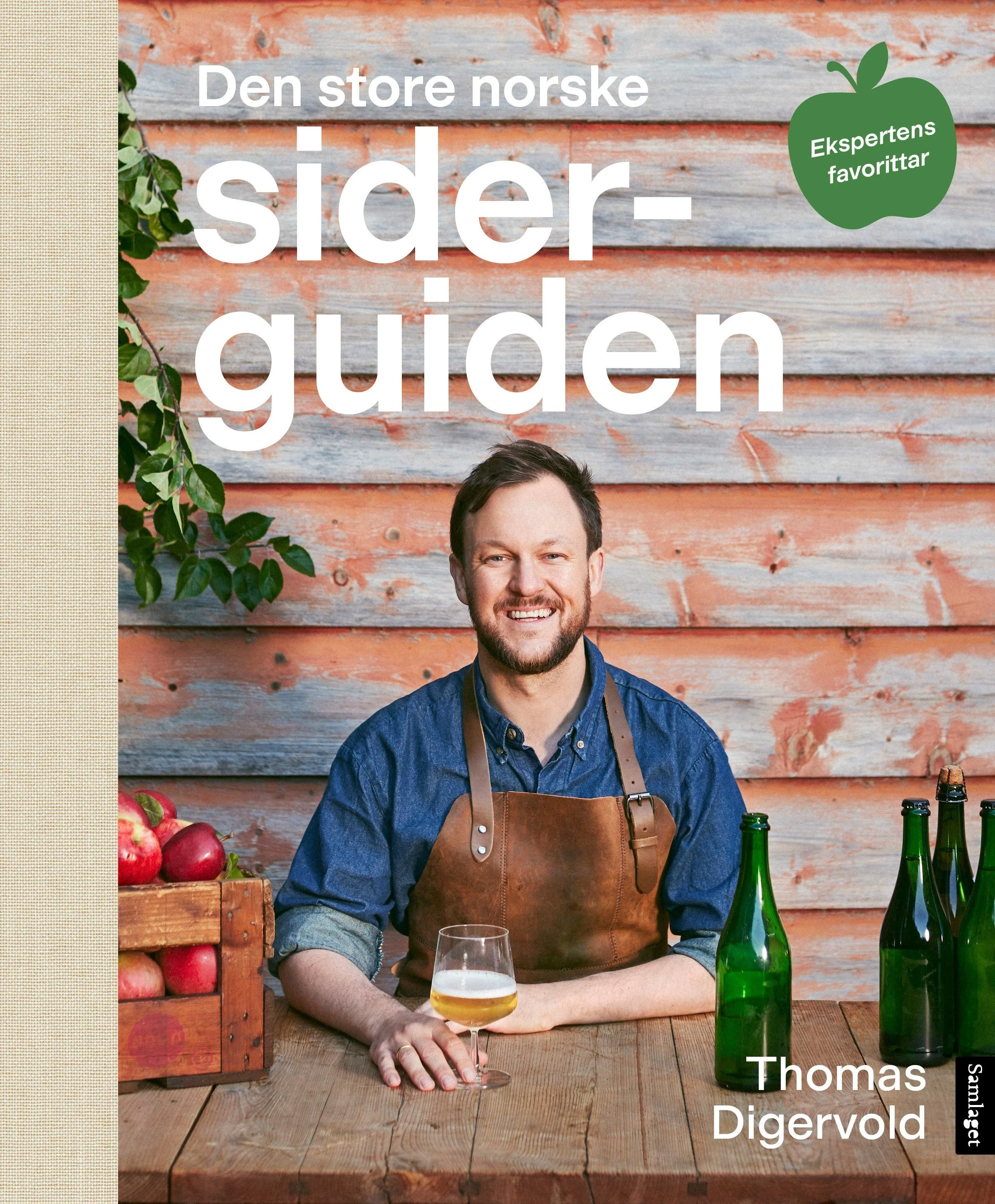 Book cover titled 'Den store norske sider-guiden' by Thomas Digervold showing a man sitting at a wooden table with a glass of beer, several green bottles, and a crate of apples, in front of a rustic wood wall.