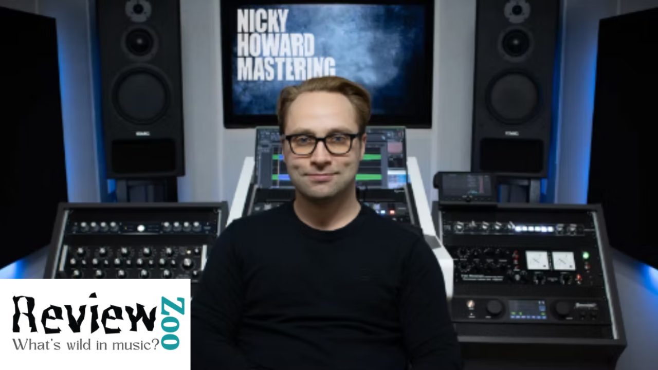A man with glasses and a black shirt sitting in a music studio with mixing equipment and large speakers. A screen behind him displays the text 'NICKY HOWARD MASTERING' and the bottom left corner has a logo that says 'Review 200z: What's wild in music?'.