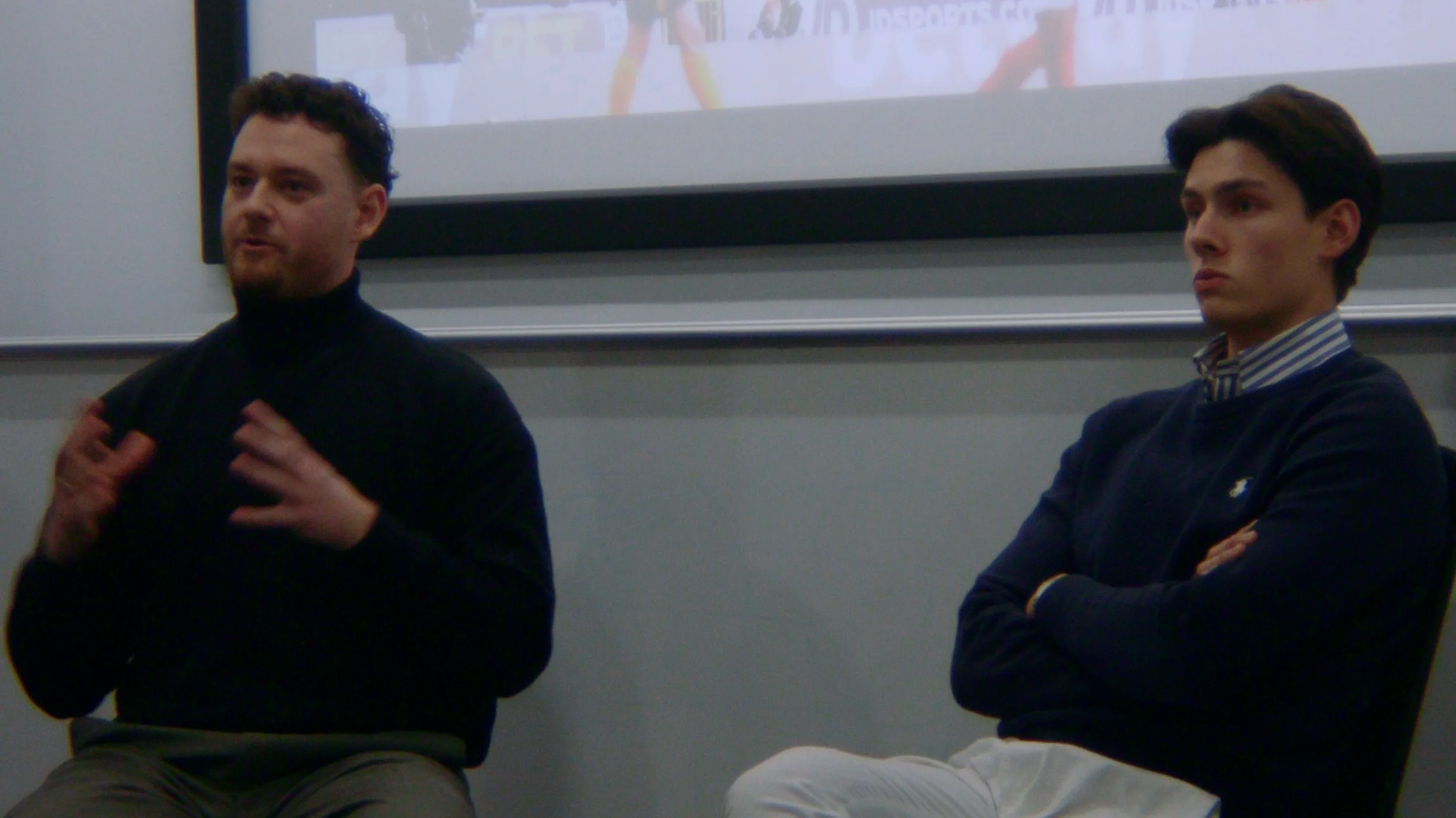 A photo of speakers Thom and Alexei in front of a screen during the talk