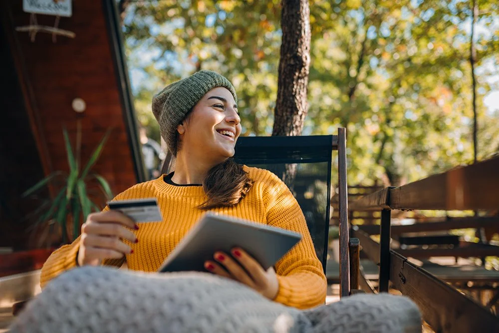 Person sitting outside with credit card and device