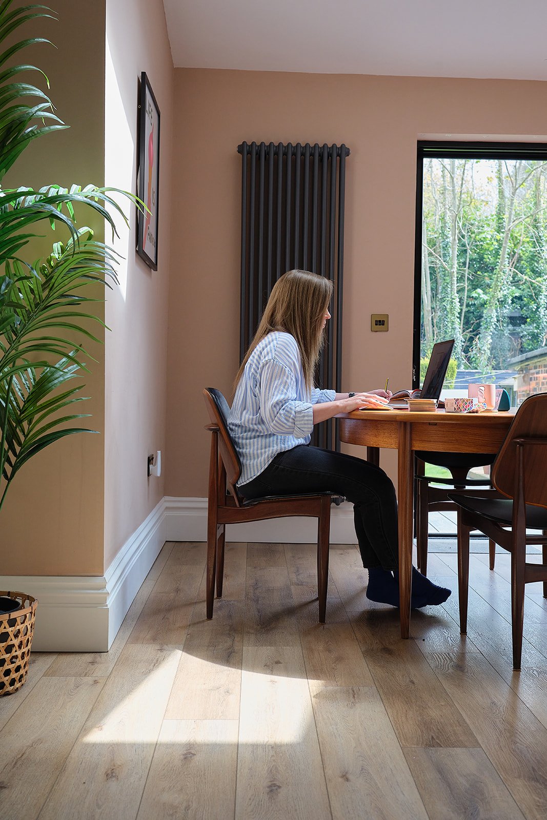 Catherine Giaquinto sat at mid century dining table working on a Brand Identity