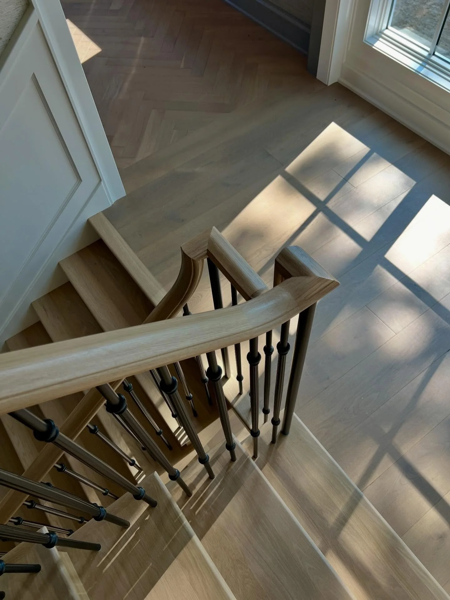 From the first floor to the second-story landing, every transition was intentional.

A custom tile inlay sets the tone&mdash;grounding the space before the stair begins to unfold.

The stair itself leans traditional in its detailing, with custom meta
