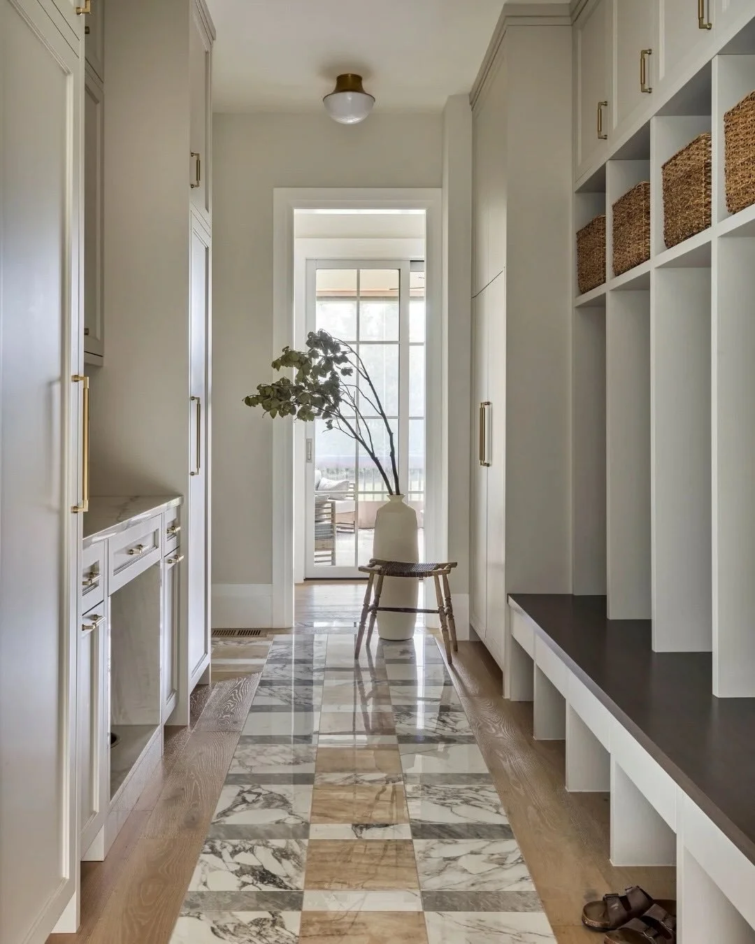 A mudroom designed to work hard without feeling utilitarian.

The custom porcelain tile inlay was selected for durability, but the veining and variation are so convincing it reads like true marble at first glance. Paired with warm oak flooring and so