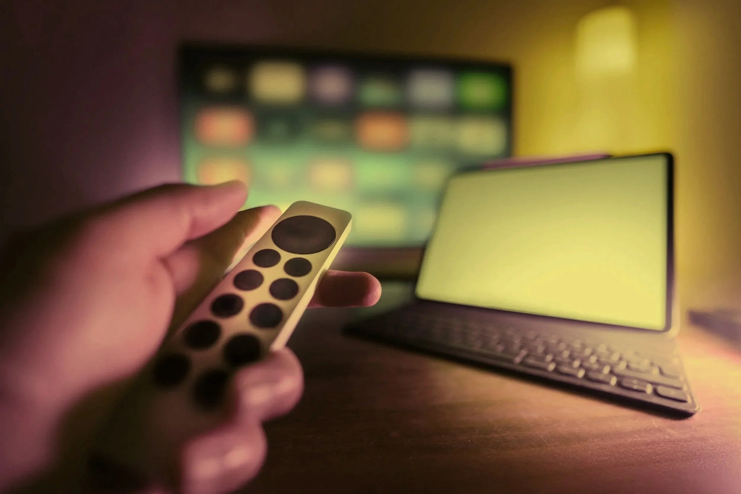 A hand holding a remote to use the smart tv to watch home movies