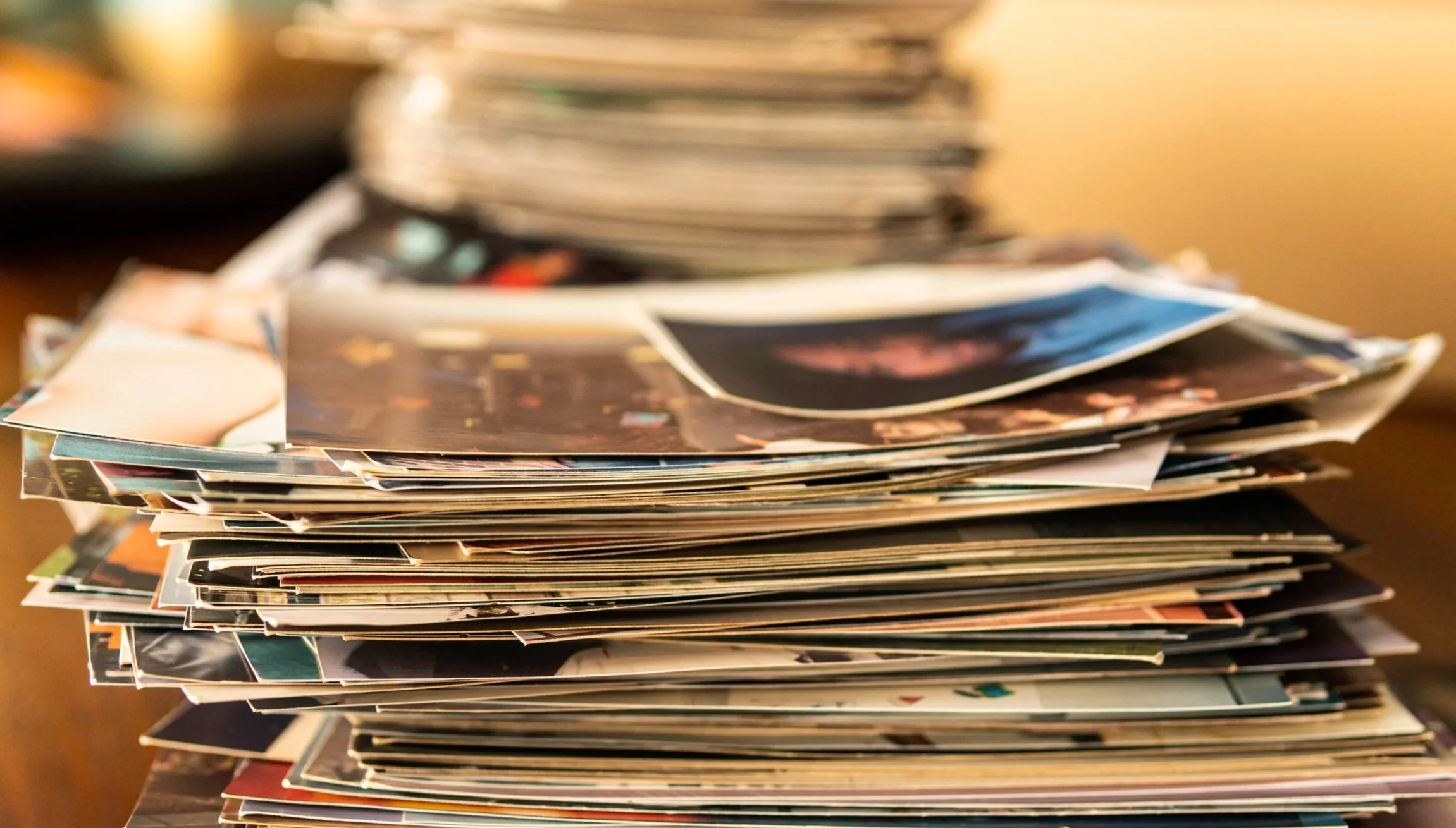 a pile of old photographs stacked up on a table