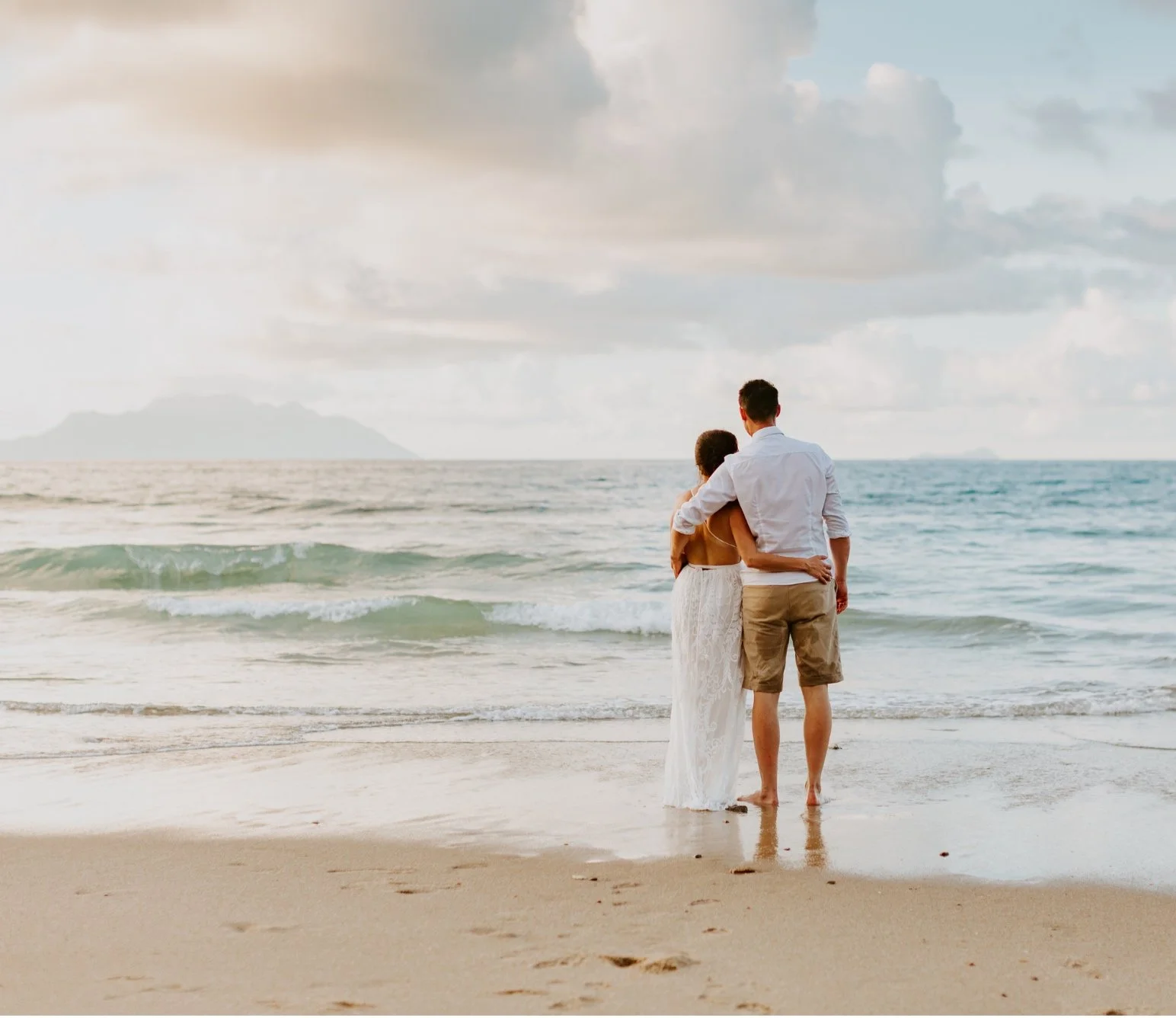 Couple embracing at sunset on Los Cabos beach ocean view