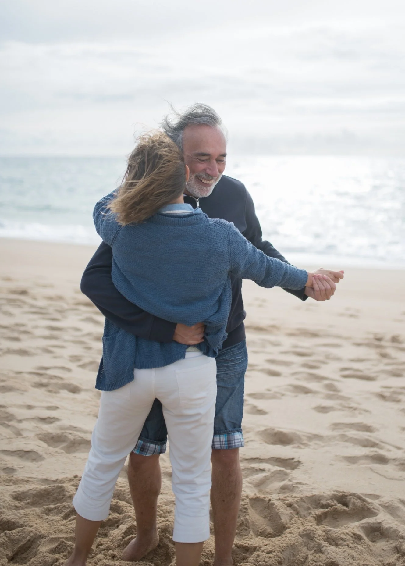 Retired couple dancing on sandy beach in Mexico lifestyle moment