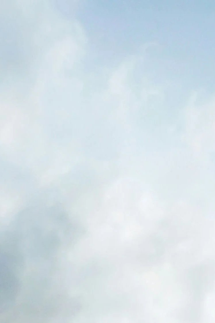 The element of air, of wind, represented by sparse clouds.