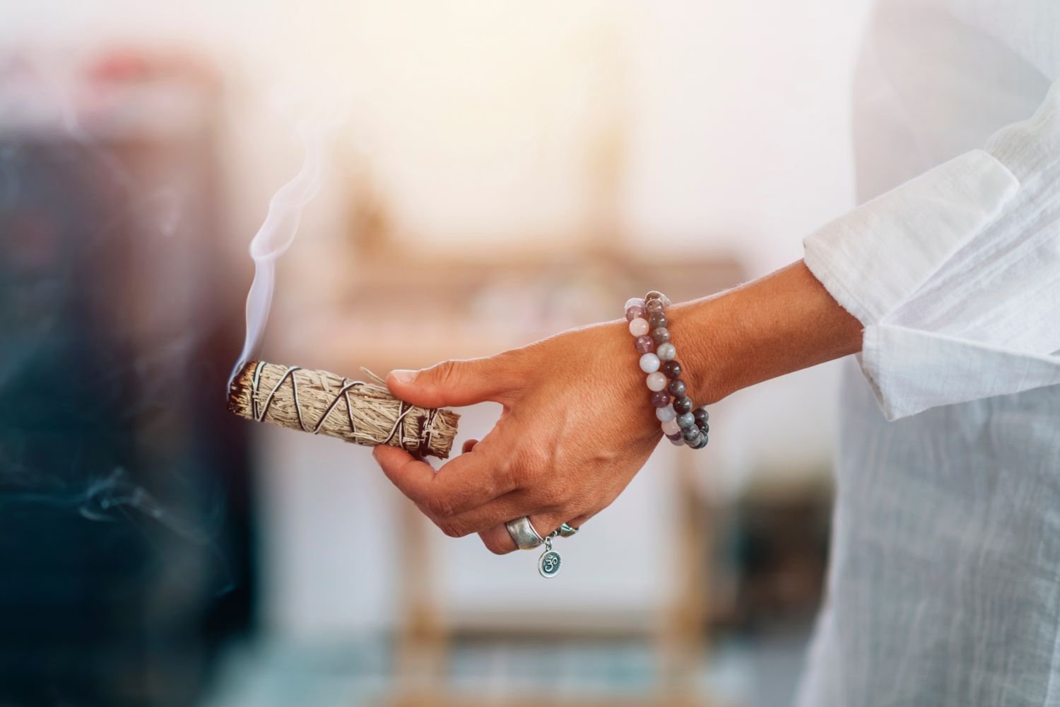 Woman burning sage to prepare for spiritual healing.