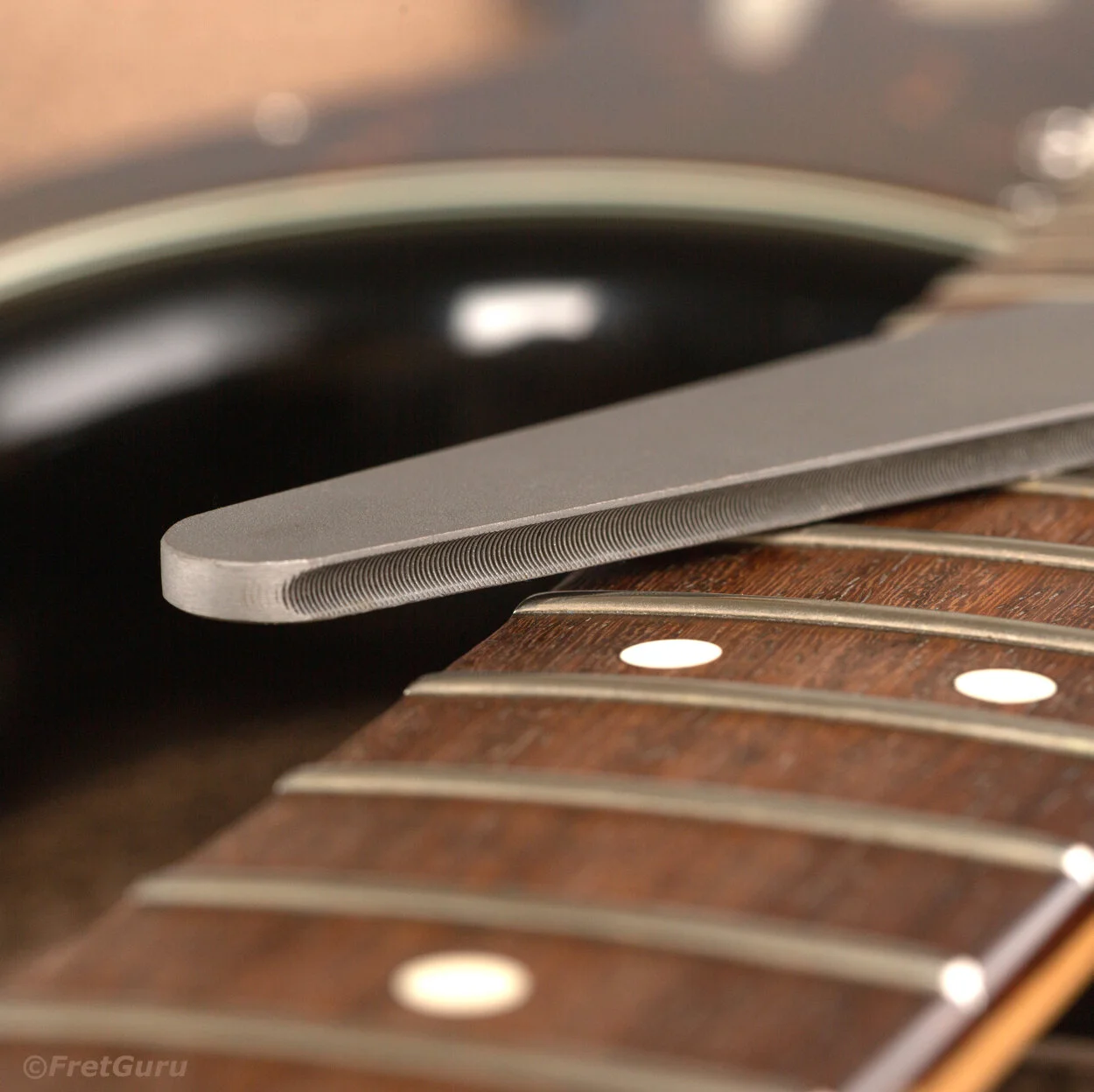 fretguru-dagger-guitar-fret-crowning-file-cutting-surface-closeup-on-guitar-neck-v2.jpg
