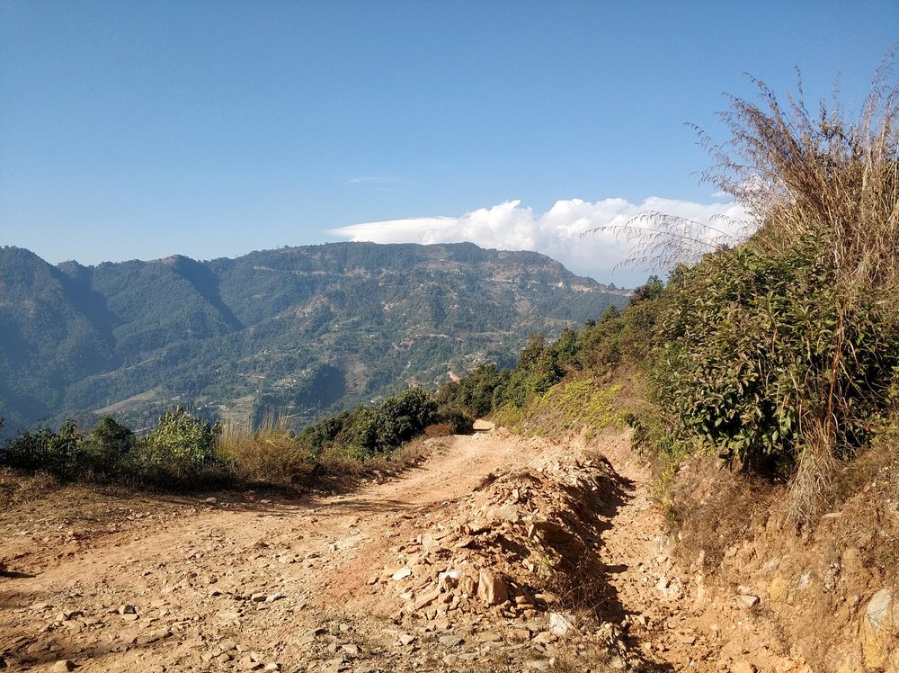  More dirt road with photogenic green hilly backdrop 