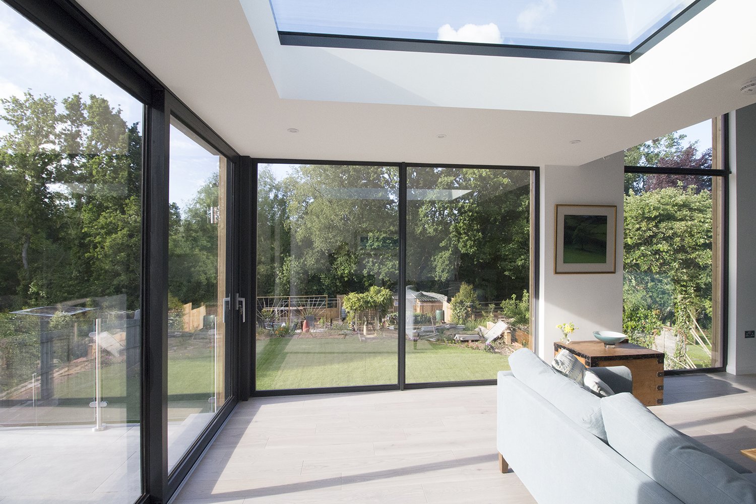 Contemporary bungalow extension at Tidcombe in Tiverton, Devon, featuring floor-to-ceiling glazing, a large rooflight and an open-plan living space overlooking the garden.