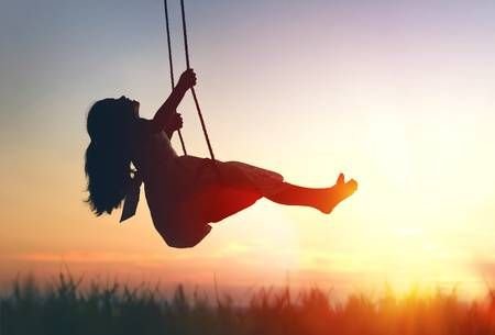 Happy laughing child girl on swing in sunset summer.jpg