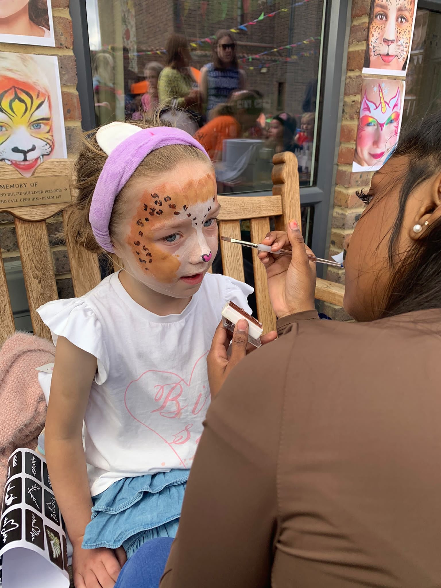 Isla, age 5, having her face painted at the carnival