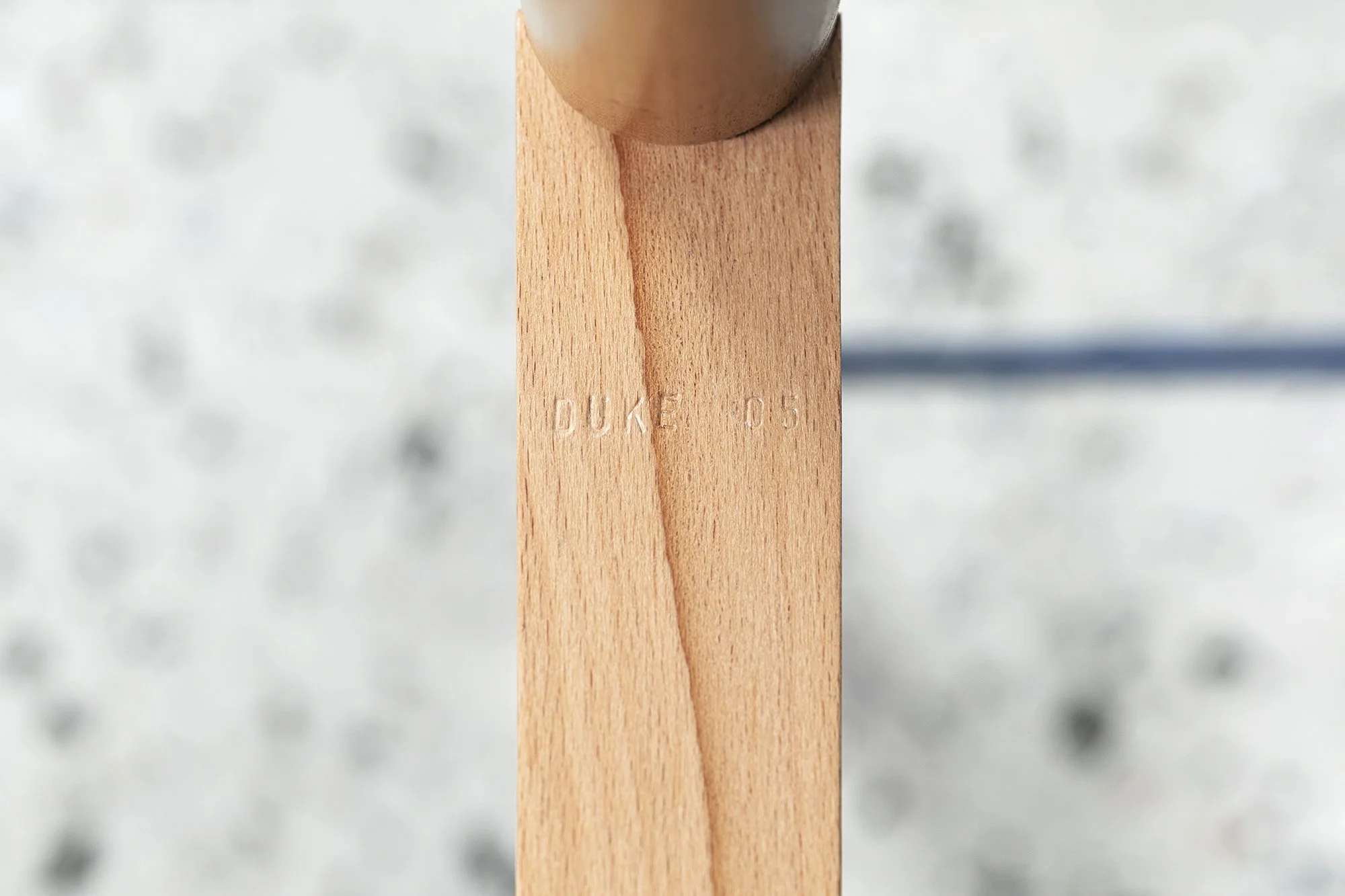 Vue rapprochée d'un poteau en bois avec l'inscription "DUKE 05" gravée.