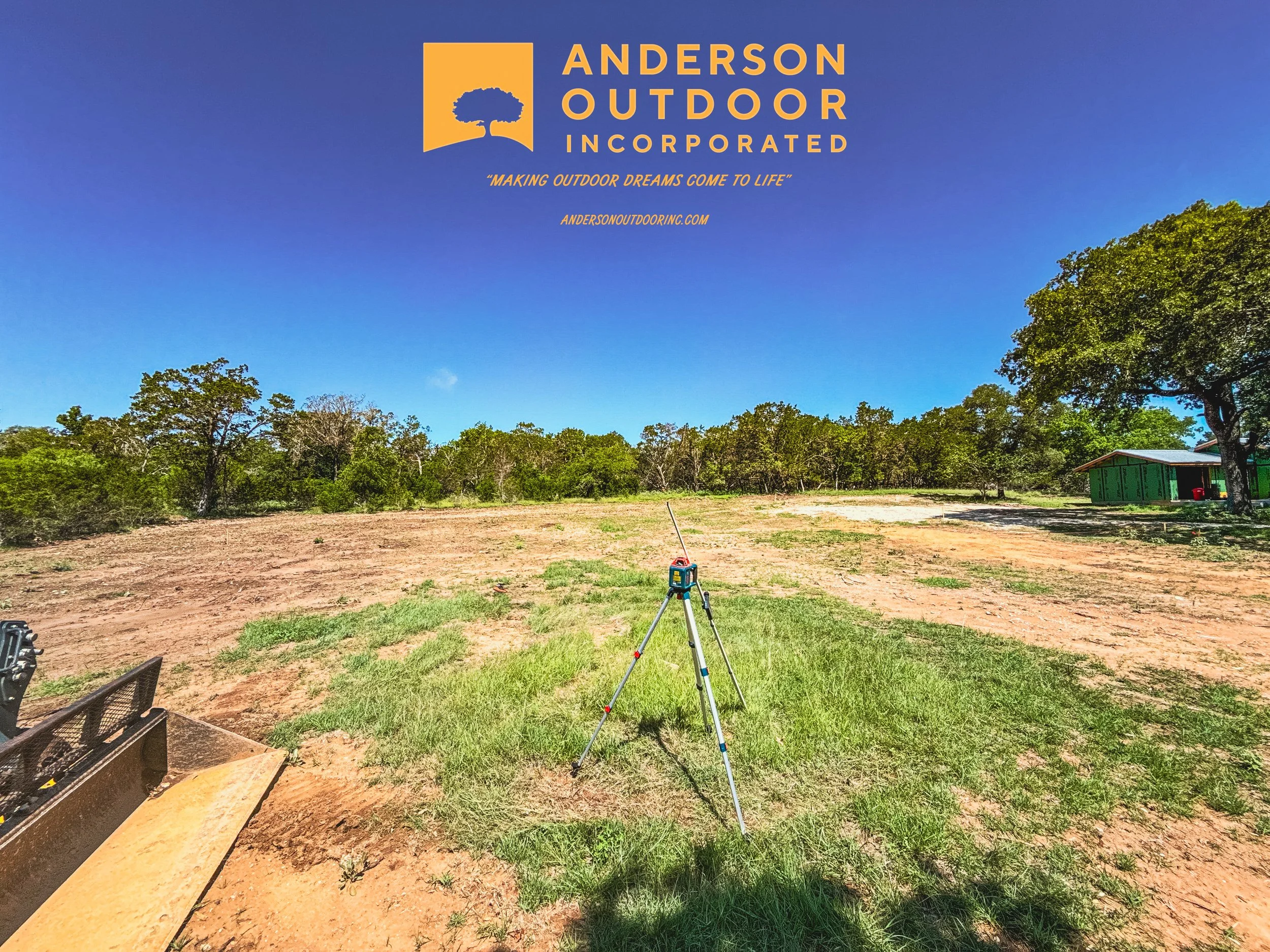 Logo of Anderson Outdoor Incorporated over a landscape with dirt, grass, trees, and a small green building; surveying equipment on the ground.