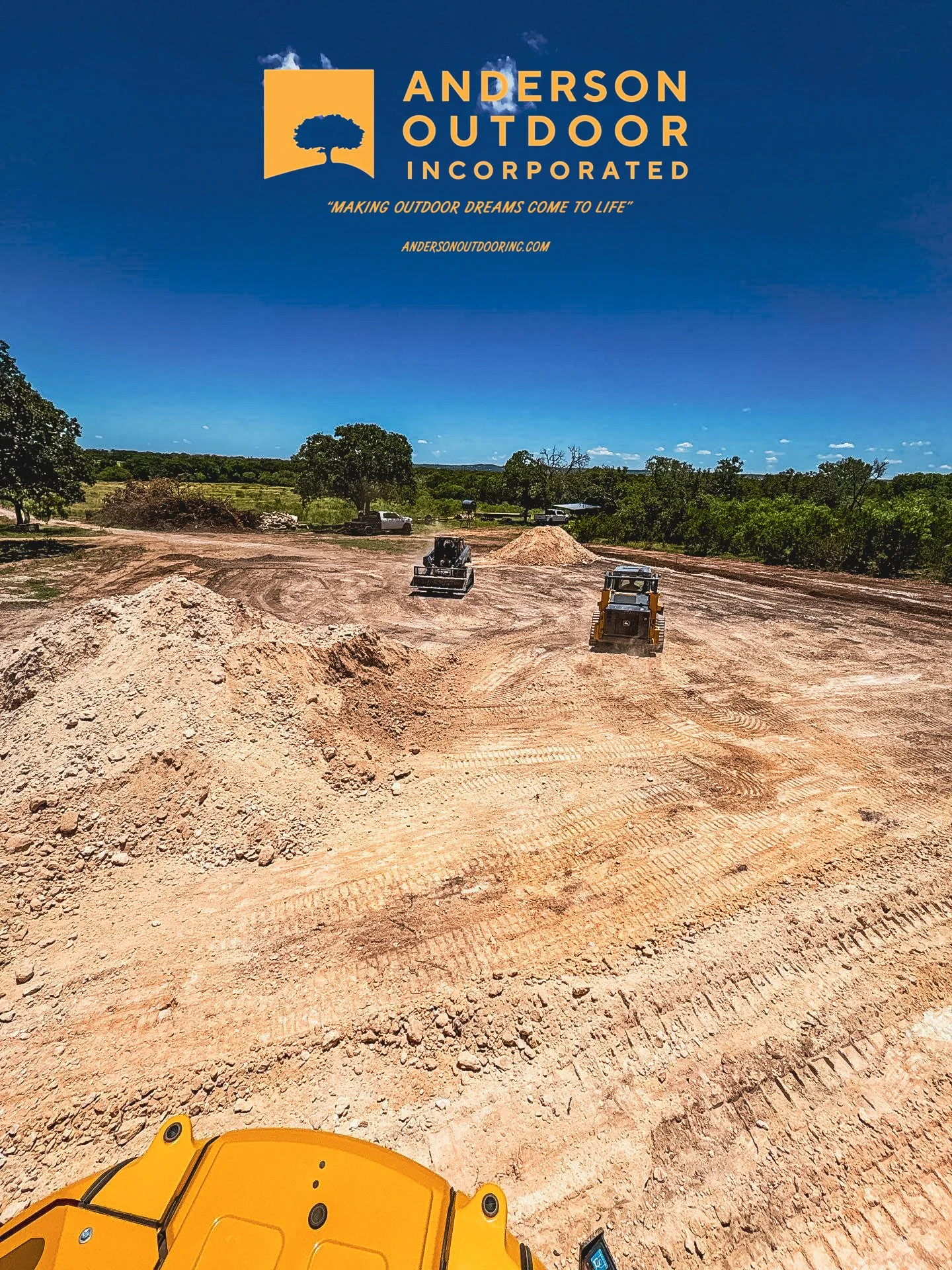 Construction site with dirt mounds, machinery, and trees under a blue sky, logo of Anderson Outdoor Incorporated at the top.