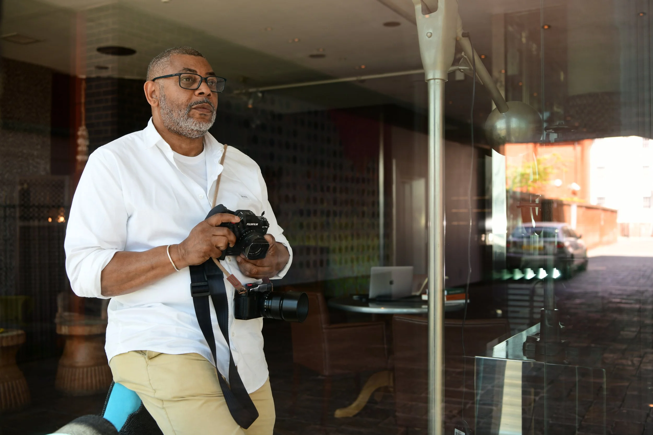 john Ferguson personal branding shoot looking out window with camera