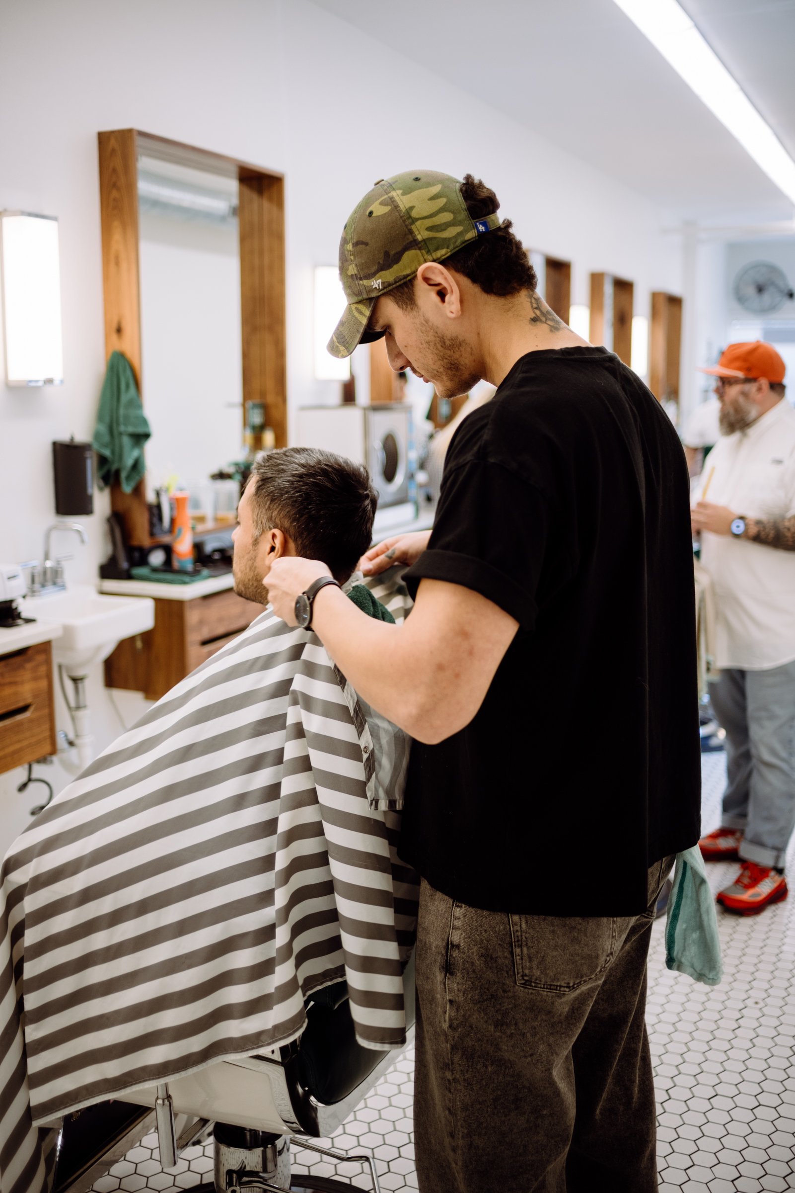 Barber in Austin Texas preparing his client for a haircut at Honest Barber