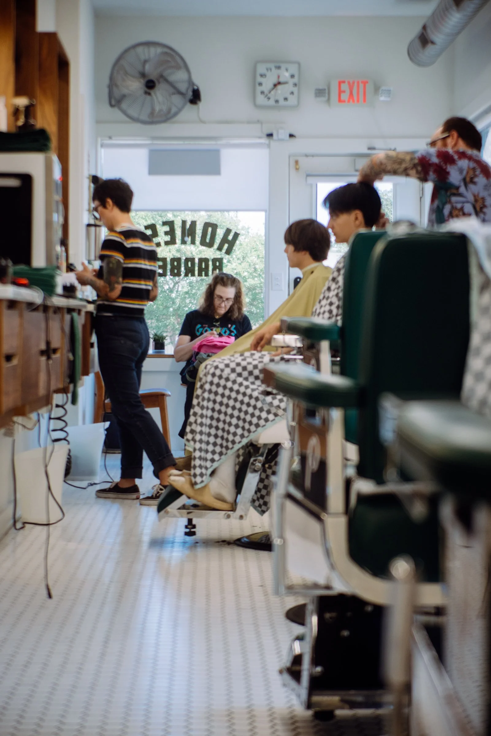 Barber cutting a young client’s hair at Honest Barber, a family-friendly barbershop in Austin.