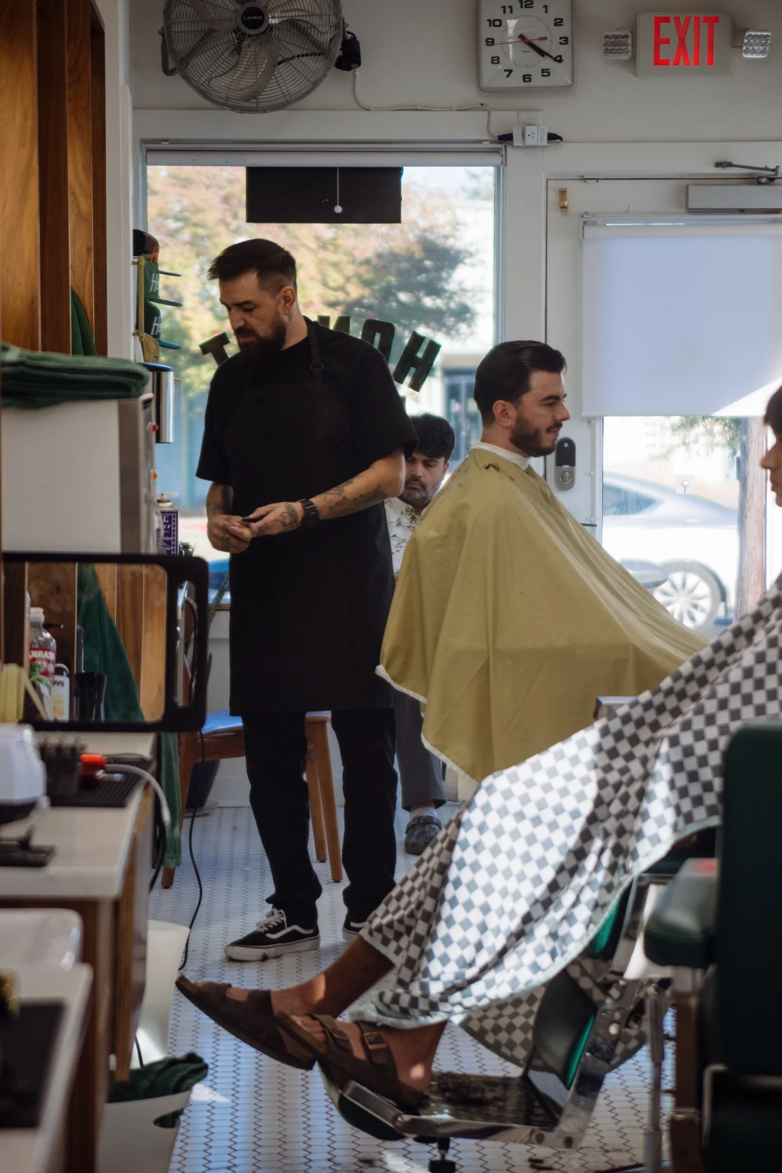 Professional barber at Honest Barber Austin preparing tools for a men’s haircut in a bright, welcoming barbershop.