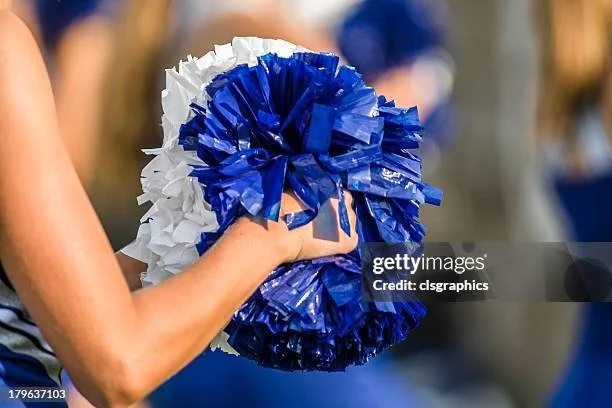 Close-up of a person's hand holding blue and white pom-poms during a cheerleading event. oms Clinic in Wheat Ridge, CO Aravada, CO Golden, CO

