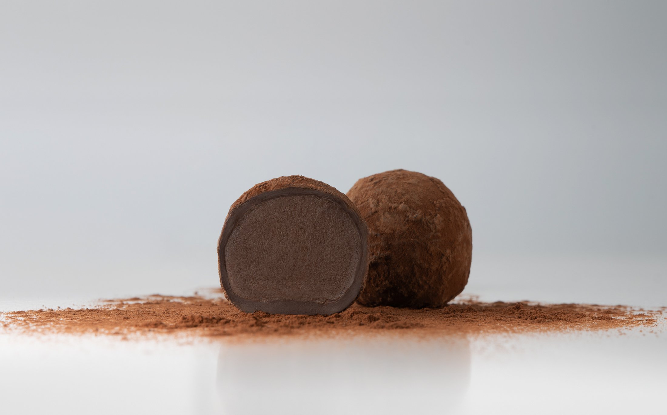 glamour shot of a cut Dark chocolate bitter truffle covered in cocoa powder