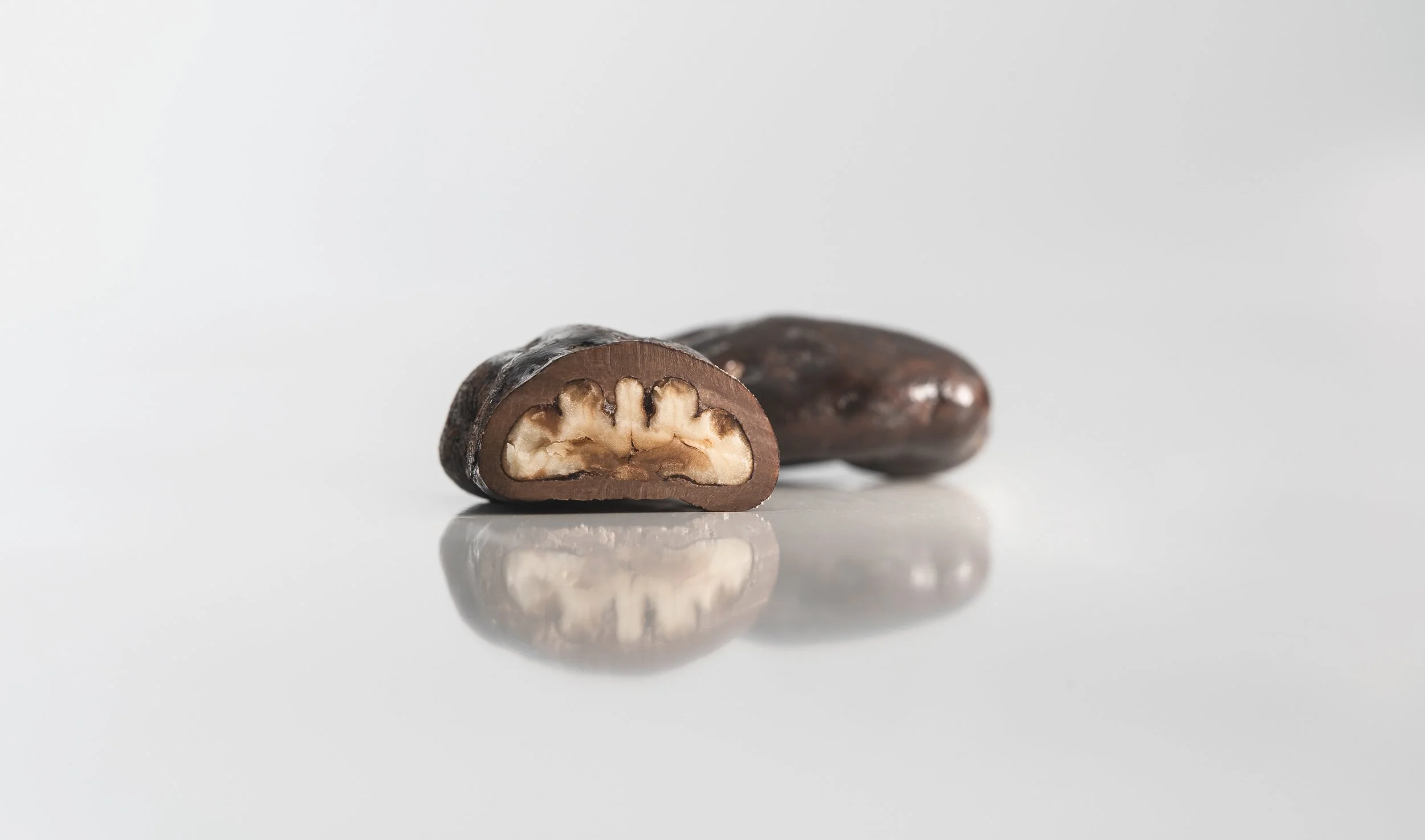 Pecan Toffee Dragees featuring crunchy pecans coated in caramelized toffee and premium chocolate.
