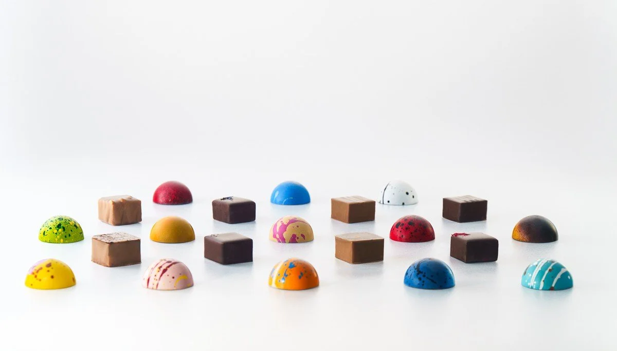 Luxury chocolate bonbons with vibrant finishes in elegant gift box