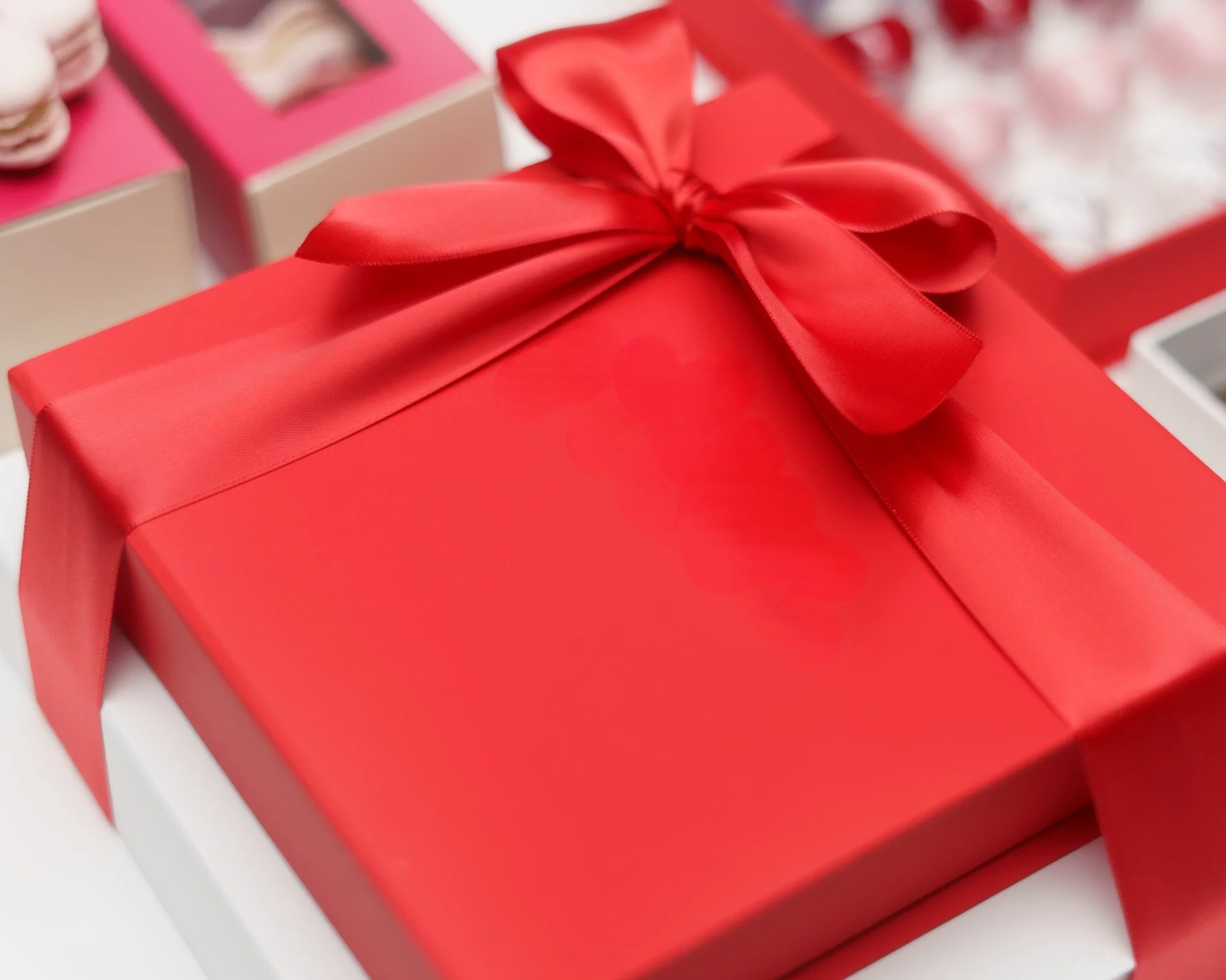 Tower of red and white chocolate gift boxes closed with a red silk ribbon