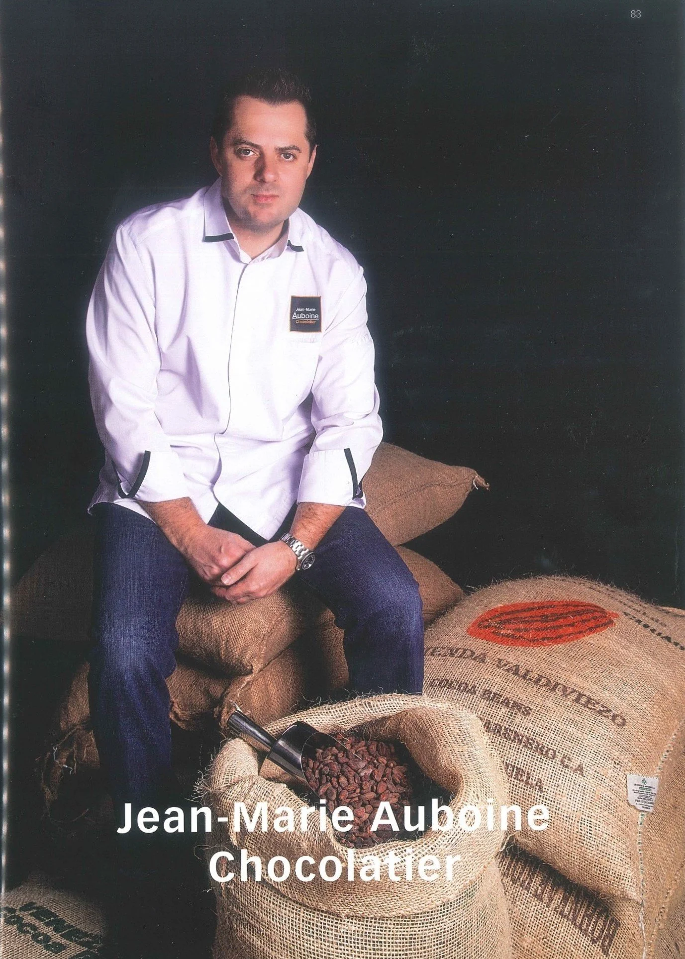 Master Chocolatier Jean-Marie Auboine with cocoa beans highlighting handcrafted chocolate expertise