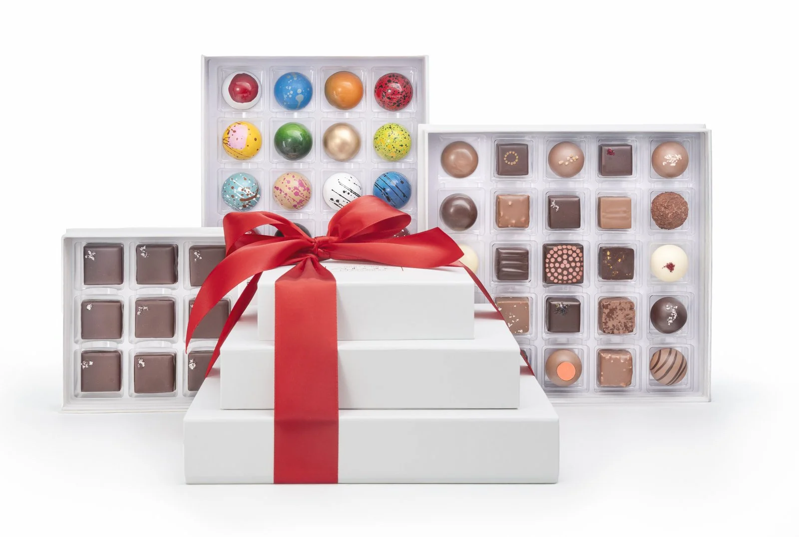 Corporate holiday chocolate gift boxes with assorted bonbons and red ribbon presentation
