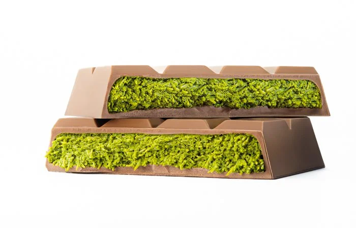 Stacked Dubai Bars revealing crunchy kadayif and pistachio layers inside rich milk chocolate.