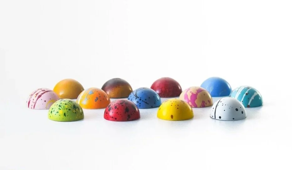 Assorted colorful chocolates with artistic designs and handcrafted fillings