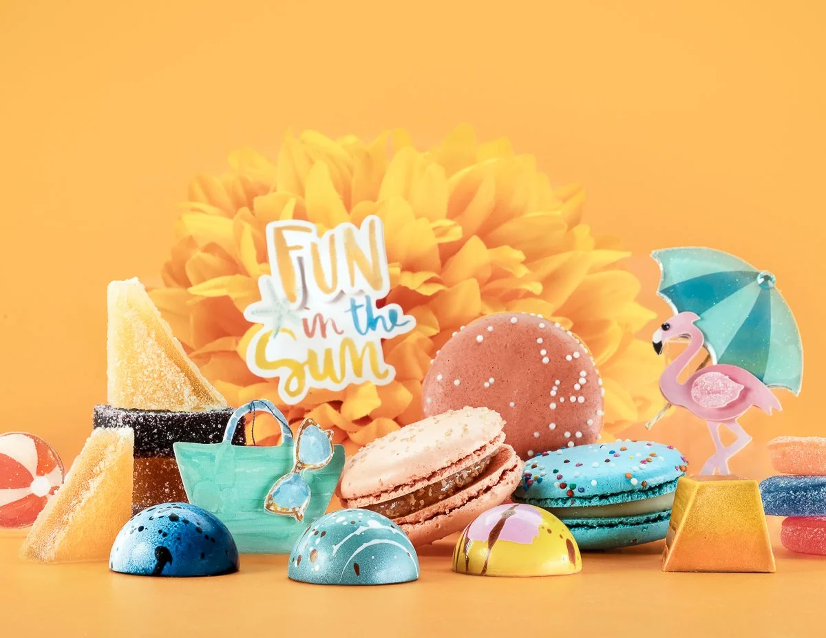 Display of summer-friendly treats by Jean-Marie Auboine Chocolatier with french macarons, pate de fruit and gummies