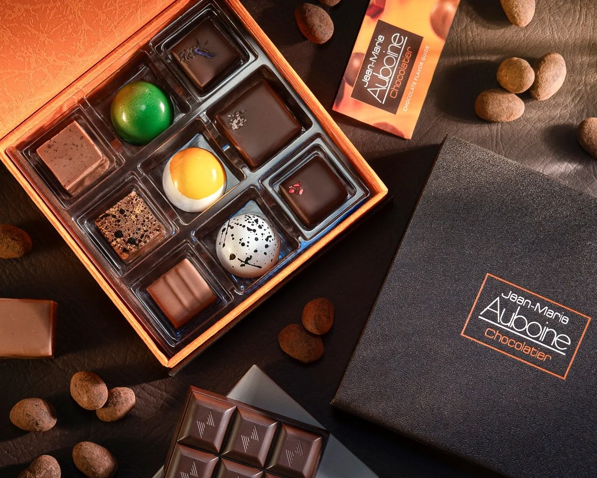 Jean-Marie Auboine Chocolatier Premium 9pc Assorted Box Displayed on a table with chocolate almonds
