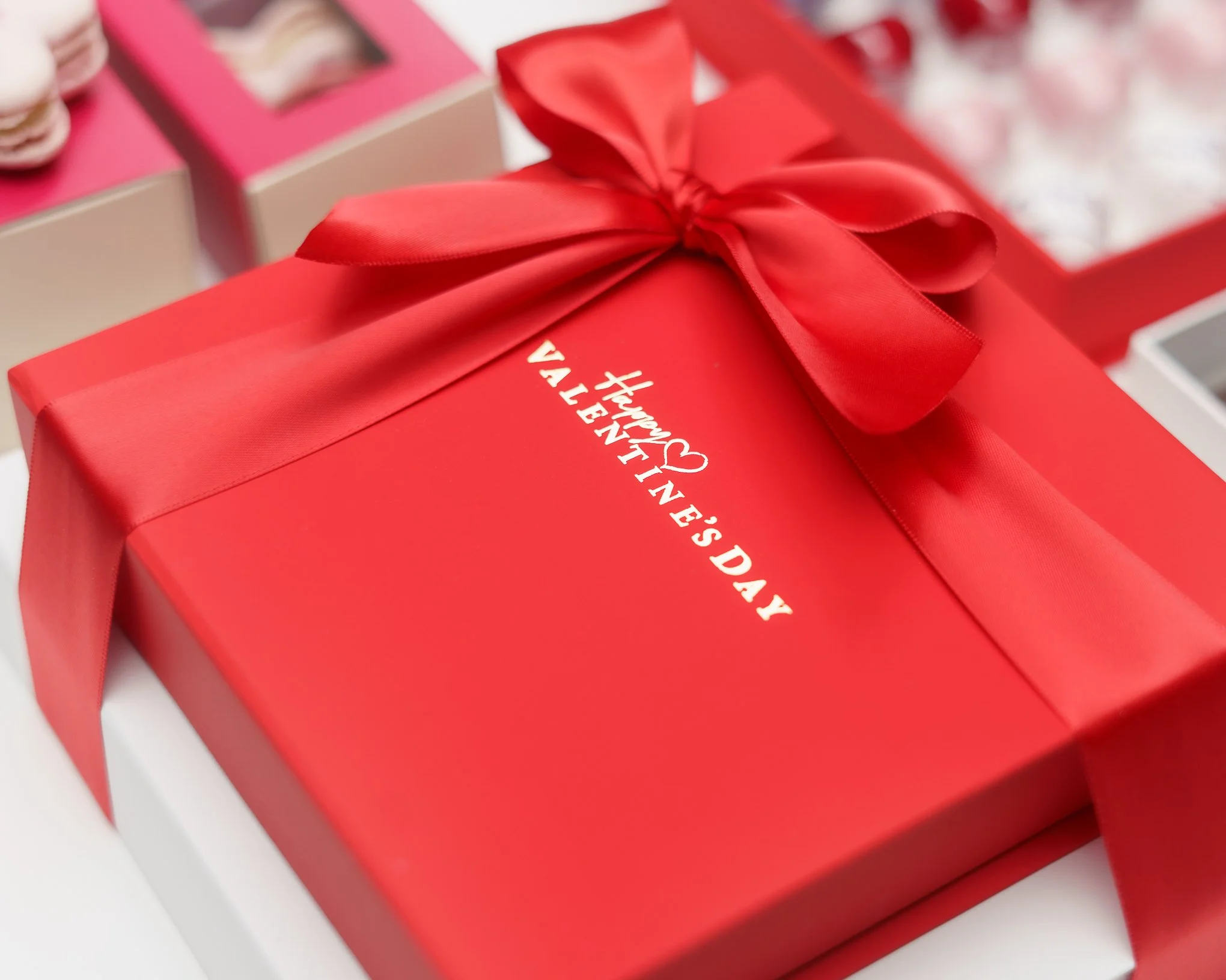 Elevated Tower of two curated chocolate boxes closed with a silk red ribon perfect as a premium gift for your love