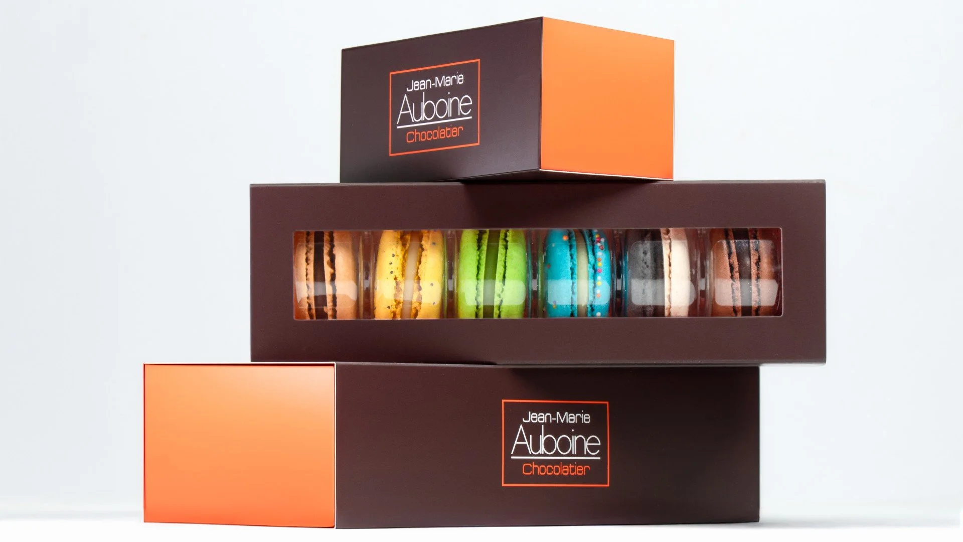 Brown and orange signature boxes of gourmet French Macarons