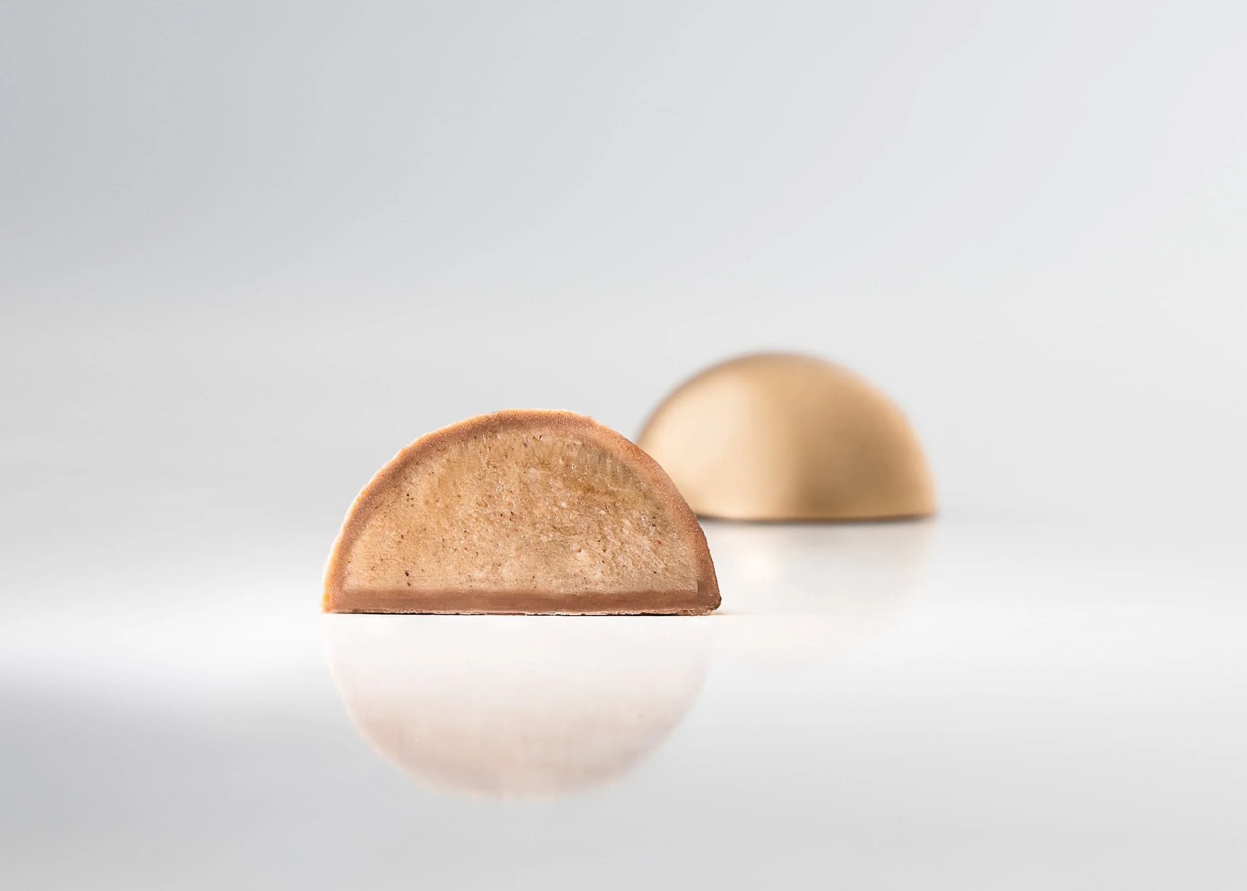 Thin shell chocolate bonbon showing clean snap and smooth texture