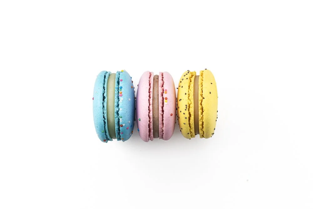 Assorted premium French macarons in pastel colors with delicate handcrafted shells.