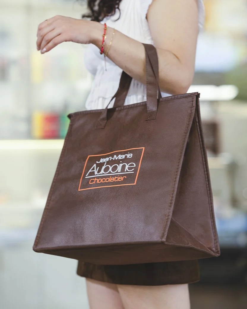 Customer carrying insulated Jean-Marie Auboine chocolate bag during summer shopping in Las Vegas
