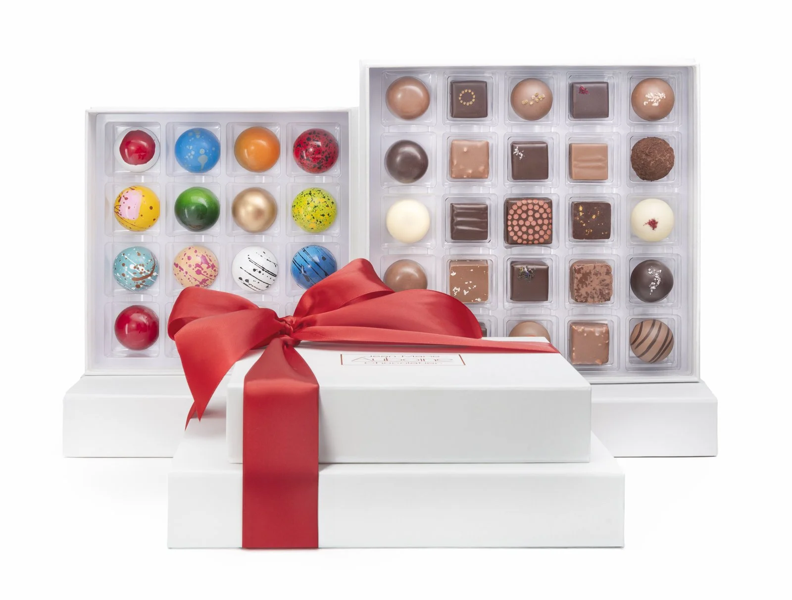 Grand Tasting chocolate tower with assorted bonbons and truffles displayed behind gift boxes