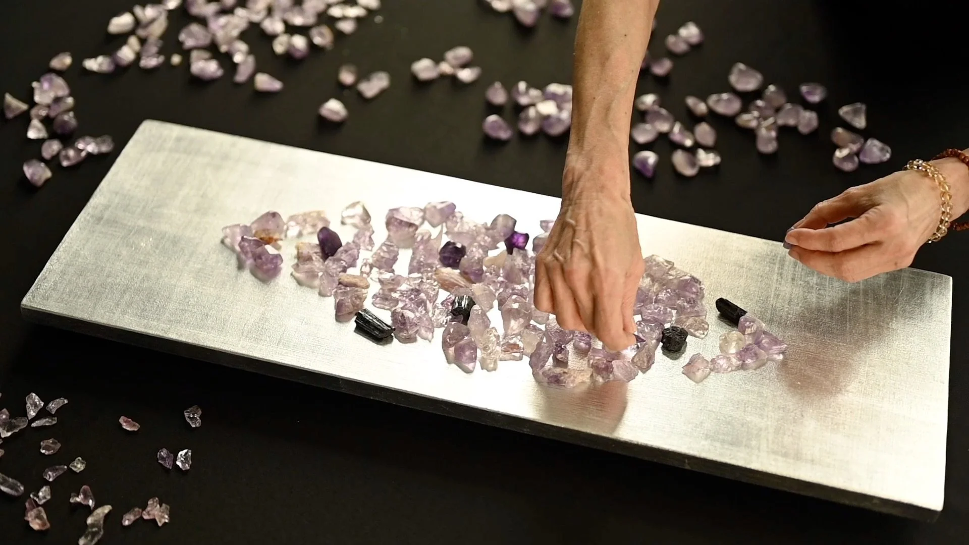 Crystals being placed on the surface of a Mandorla wall sculpture