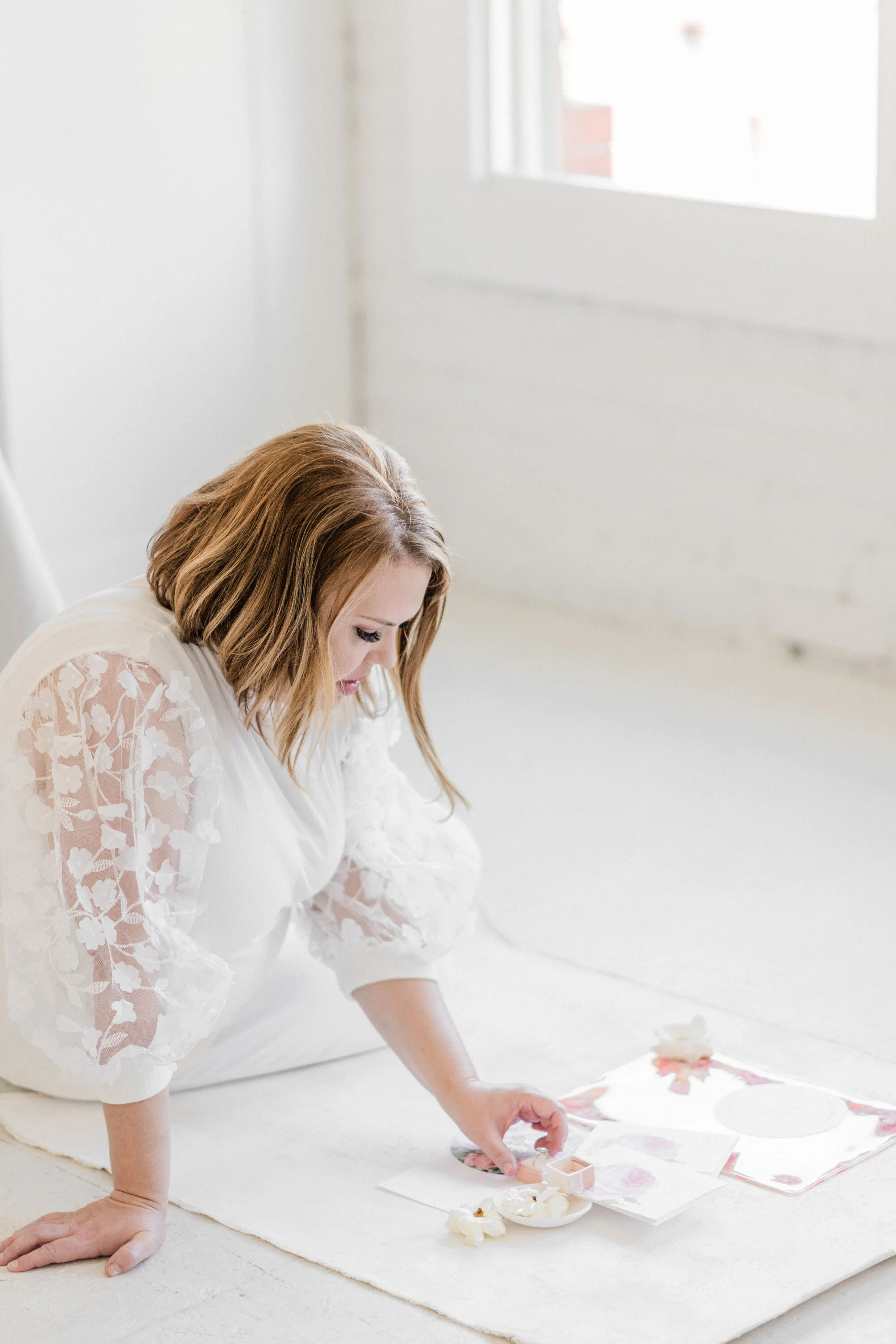 Virtual Assistant Lori Losee setting up a wedding invitation flatlay.